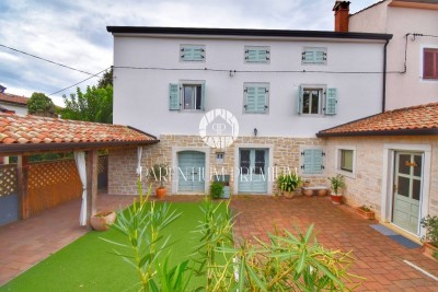 Ein einheimisches Steinhaus, das letzte in einer Reihe, mit einem Garten