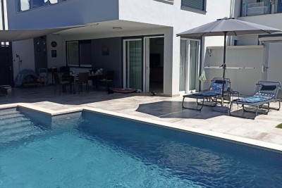 Luksuzno stanovanje z ogrevanim bazenom, čudovitim in funkcionalnim vrtom ter pokritim, zaklenljivim parkirnim prostorom za štiri avtomobile